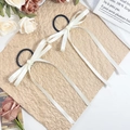 Set di due eleganti elastici per capelli con lunghi nastri di raso crema su uno sfondo vintage - Beige