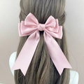 Eleganter rosa Satin-Haarclip mit dreilagiger Schleife und langen Bändern am Modell - Rosa