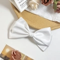 Detail of a large white satin bow hair clip with elegant silk texture for hair styling - White