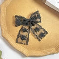 Detailed macro view of vintage black lace bow hairpin with intricate floral embroidery - Black