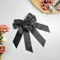 Makroansicht der schwarzen Satin-Schleife Haarspange mit eleganten langen Bändern - Schwarz