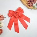 Detail of red satin bow hair clip with long streamers and elegant glossy finish - Red