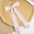 Détail d'une pince à cheveux en ruban rose avec broderie en dentelle fleurie blanche - Rose