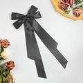 Detail of elegant black satin bow hair clip with long ribbons and smooth silk texture - Black