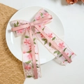 Detail of pink organza hair clip with floral embroidery and elegant bow ribbons - Pink