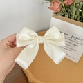 Detailed view of elegant creamy white satin ribbon hair clip with double-layer bow design - Off White