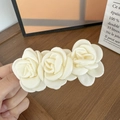 Detail of three cream satin camellia flowers on a spring hair clip with soft fabric texture - Beige Satin