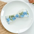 Dettaglio del fermaglio a fiocco in pizzo con ricamo floreale blu e bordi beige - Stile Ricamato in Pizzo-Blu