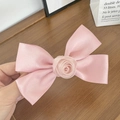 Détail de la pince à cheveux avec nœud en satin rose et fleur de rose texturée élégante - Rose