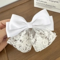 Detail view of a white lace bow hair clip featuring fine floral embroidery and silk satin - Style A White