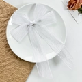 Close-up of a white pleated mesh bow hair clip with long ribbons in a minimalist tray - White