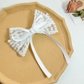 Detalle de un lazo de encaje blanco para el cabello con cinta sobre una bandeja vintage - Blanco