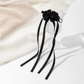 Détail de roses en tissu faites à la main et longs rubans sur une pince à cheveux - Noir