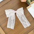 Detail of pink lace bow hair clip with faux pearls and heart-shaped gemstone - Pink