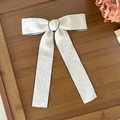 Detalle del lazo para el pelo en jacquard blanco con ribete negro y cintas largas - Beige