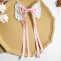 Detalle del lazo de raso rosa para el pelo con encaje blanco en bandeja beige - Rosa