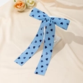 Sweet light blue ribbon hair clip with dark blue heart patterns on beige fabric background - Blue