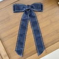 Detailed close-up of dark blue jacquard floral bow hairclip with white double stitching - Navy Blue