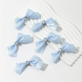 Détail de 6 barrettes à nœuds en satin bleu clair avec centres en strass en forme de cœur - Bleu