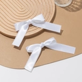 Detalle de dos lazos de satén blanco con delicados bordes festoneados en bandeja madera - Blanco (1 Par)