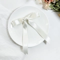 Elegante pinza para el pelo de satén blanco con lazo, encaje y cintas largas en un plato - Beige