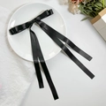 Detalle de una pinza para el pelo con lazo doble de satén negro y cintas largas elegantes - Negro
