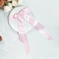 Eleganter hellrosa Satin Schleifen-Haarclip mit langen Bändern auf dekorativem Teller - Rosa