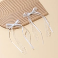Dettaglio ravvicinato di fermagli per capelli con fiocchi in pizzo bianco e nastri lunghi - Fermagli per capelli a becco d'anatra / Bianco