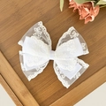 Dettaglio del fiocco in pizzo bianco con eleganti motivi floreali per capelli - Bianco
