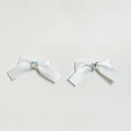 Close-up of white satin bow hair clips with sparkling rhinestone heart center pieces - White