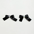 Close-up of black ribbon bow hair clips with shimmering crystal heart center decoration - Black