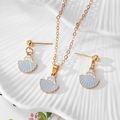 Detail of gold shell jewelry set with blue enamel on a white textured plate - Blue Shell Style (AN237)