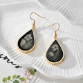 Detailed close-up of teardrop resin earrings with white dried flowers and gold foil accents - Water Drop White Flower