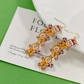 Christmas acrylic gingerbread man drop earrings with festive motifs on green background - Triple Stacked Gingerbread Man Style / Triple Gingerbread Man