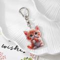 Detailaufnahme eines süßen orangefarbenen Katzen-Acryl-Schlüsselanhängers mit Karabiner - Katze mit Spielzeug