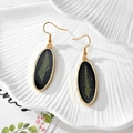 Detail of oval resin earrings with green leaf fern and gold foil on black base - Oval Green Flower