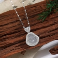 Vue détaillée du collier en argent avec pendentif Bouddha et zircons sur bois rustique - Style Bouddha F