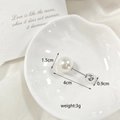 Detail shot of a dual-headed pearl brooch pin with silver metal rod on elegant shell plate - 4cm Straight Pearl Pin