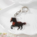 Vue macro détaillée d'un porte-clés cheval en acrylique avec fermoir en métal argenté - Cheval