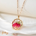 Vue macro du collier en résine dorée avec pétales rouges et fleurs séchées - Style Floral Rouge et Blanc (F)