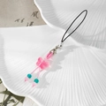 Detailed view of a pink butterfly phone charm with beads and metal lobster clasp on a plate - Pink Butterfly Style (Style E)