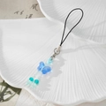 Close-up of translucent blue butterfly pendant with beads on a white ceramic dish - Blue Butterfly Style (Style H)