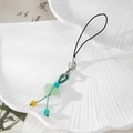 Detailed view of Chinese style jade gourd phone charm with woven cord on shell plate - Light Green Lotus Pendant Style (Style I)