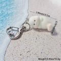 Close-up of white flocked seal charm with dimensions 3.7cm x 2cm on beach background - Lazy Seal