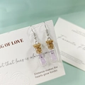 Détail de boucles d'oreilles mini bouteilles en verre avec bouchon et fantôme violet - Boucles d'Oreilles Perles Violettes