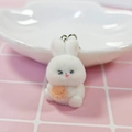 Close-up of a white flocked bunny keychain holding a carrot with a silver metal ring - Winking Bunny
