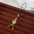 Detailed view of a resin butterfly phone charm with colorful beads on a brown velvet tray - Yellow Butterfly Style (Style M)