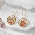 Macro detail of handmade resin earrings with pink dried flowers and gold hooks - Pink Daisy And Pink Babysbreath