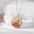 Détail d'un pendentif doré orné de véritables marguerites rouges et de fleurs séchées - Marguerite Rouge Et Gypso Jaune