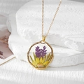 Détail d'un pendentif rond doré avec de vraies fleurs séchées violettes et jaunes en résine - Marguerite Jaune Et Feuilles Violettes